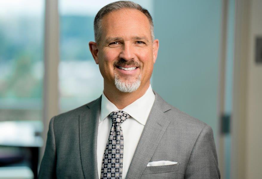 Professional man in a suit smiling at the camera.